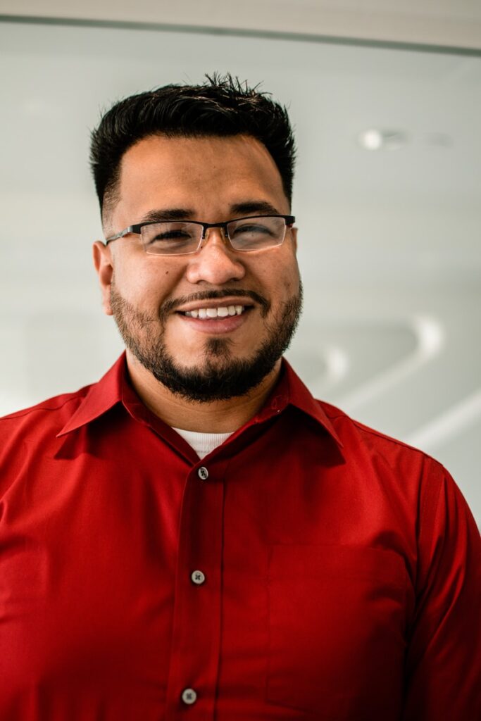 man in red button up shirt wearing black framed eyeglasses